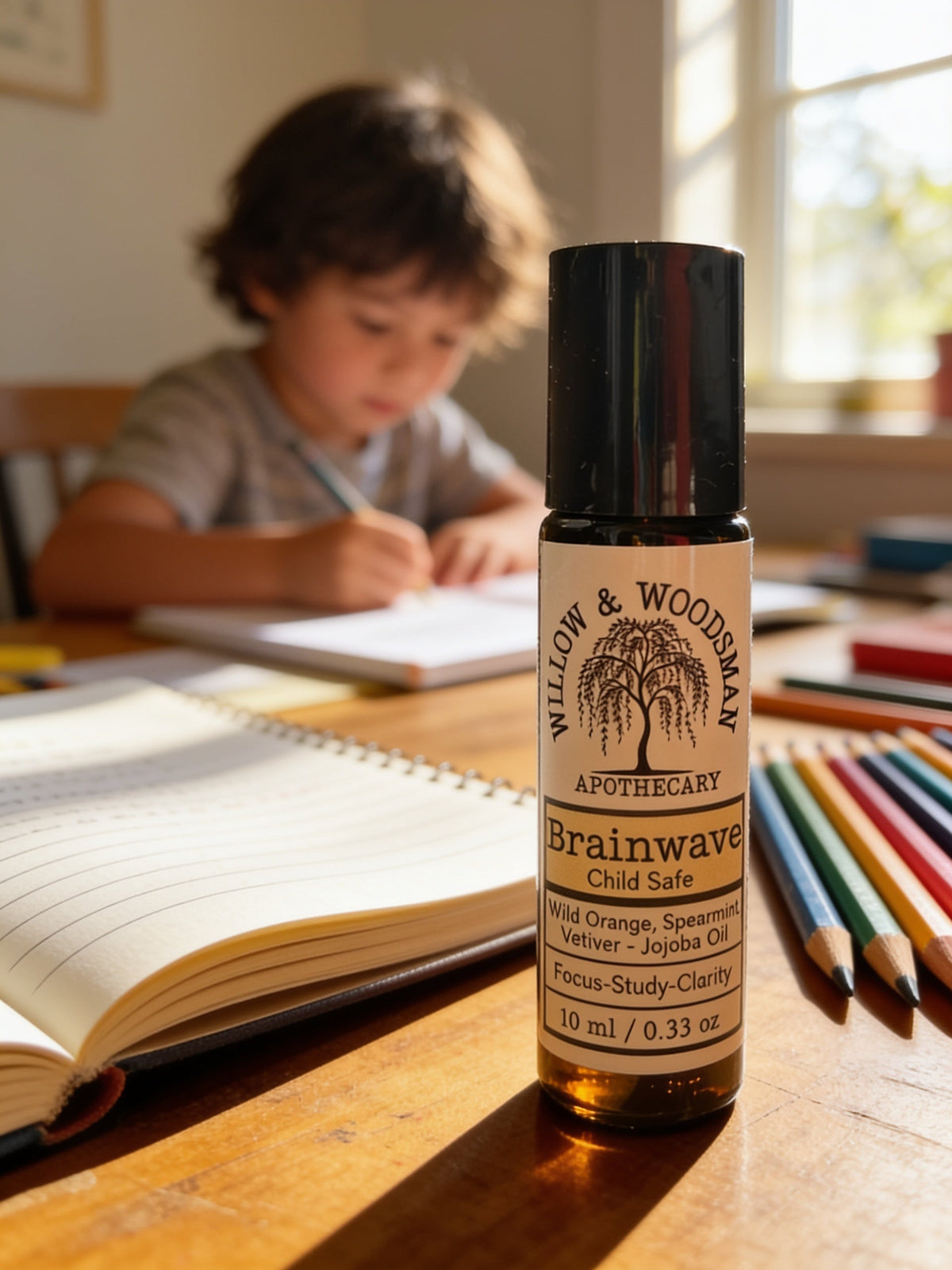 Brainwave child safe focus roller on a homework desk with a child studying in the background – Willow & Woodsman Apothecary